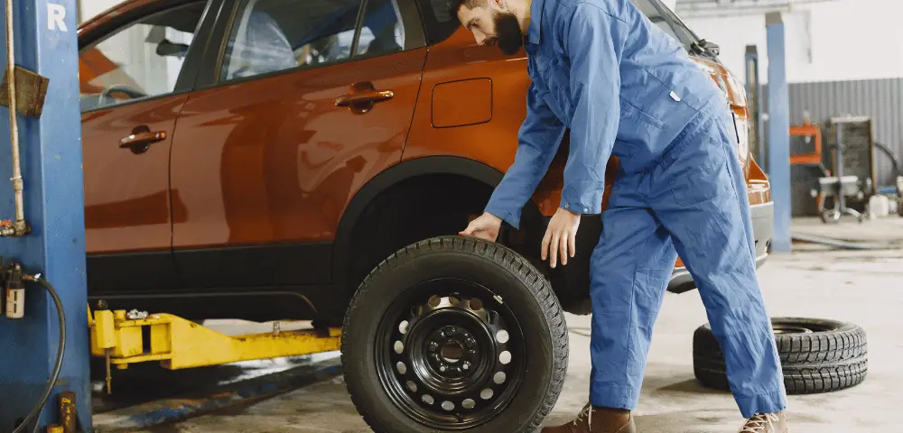 man removing tires from car