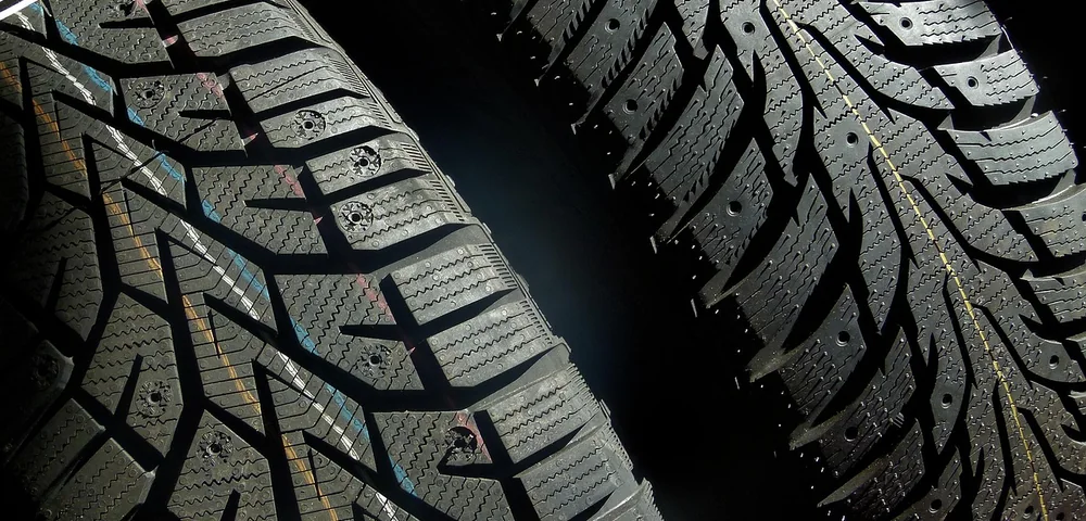 Close-up of tire tread patterns showing detailed grooves and studs on winter tires