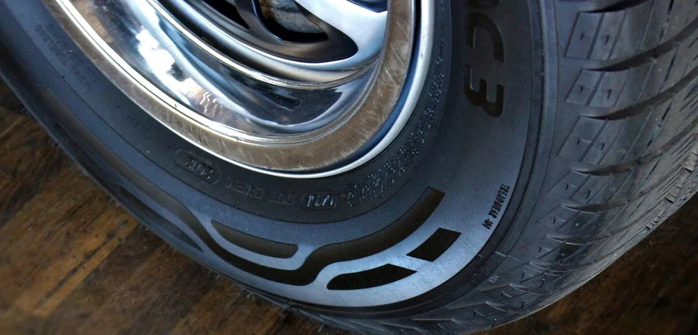 Close-up of a car tire showing tread pattern and sidewall detail on a wheel.