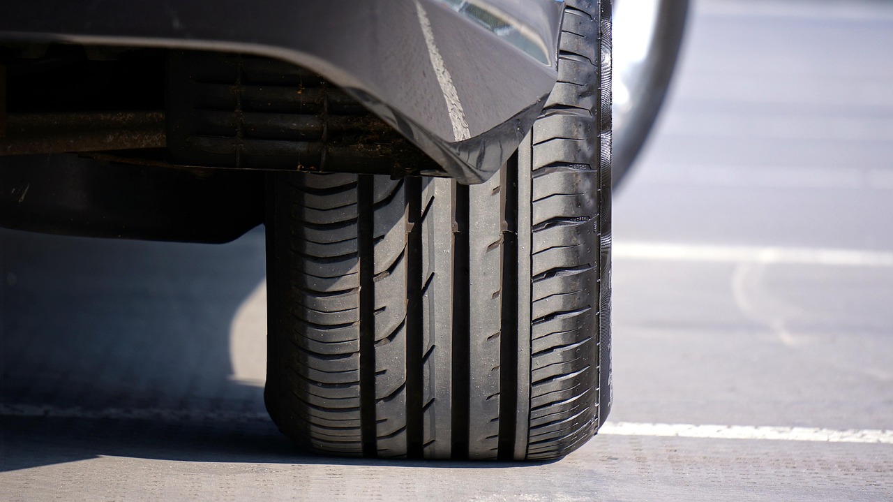 Close-up of a car tire tread and sidewall mounted on a vehicle wheel