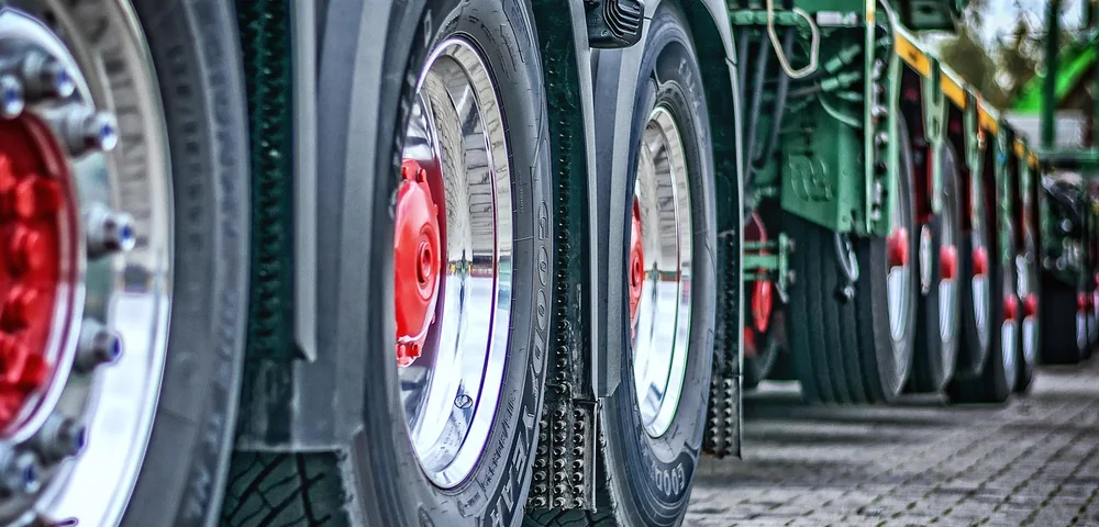 Close-up row of heavy-duty truck tires and wheels, relevant to load range ratings like LT, C, D, and E.