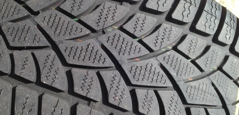 Close-up of a car tire tread pattern showing grooves for measuring tread depth