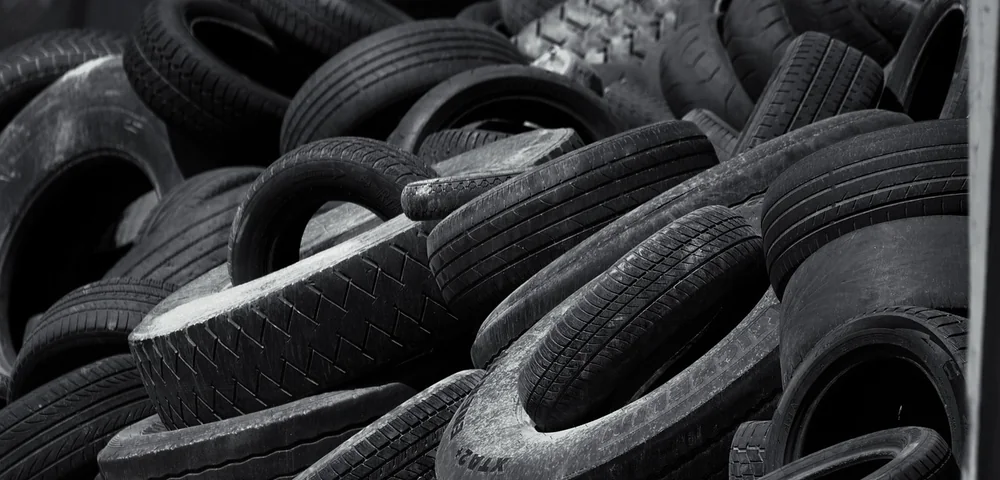 Close-up of a pile of stacked used tires in black and white