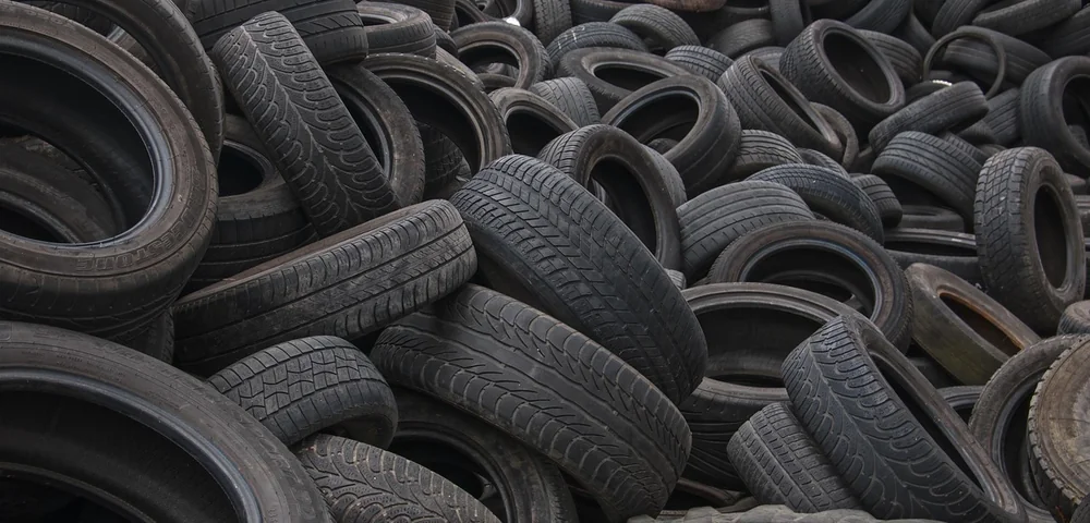 Large pile of worn used tires stacked at a tire yard